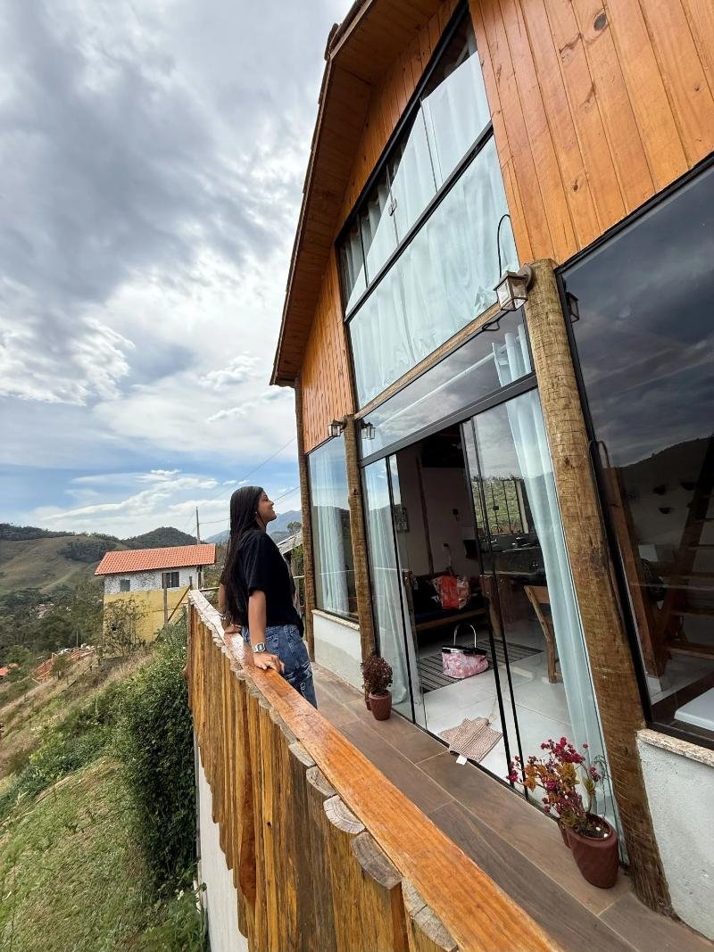 Varanda de madeira de um chalé com vista para a montanha
